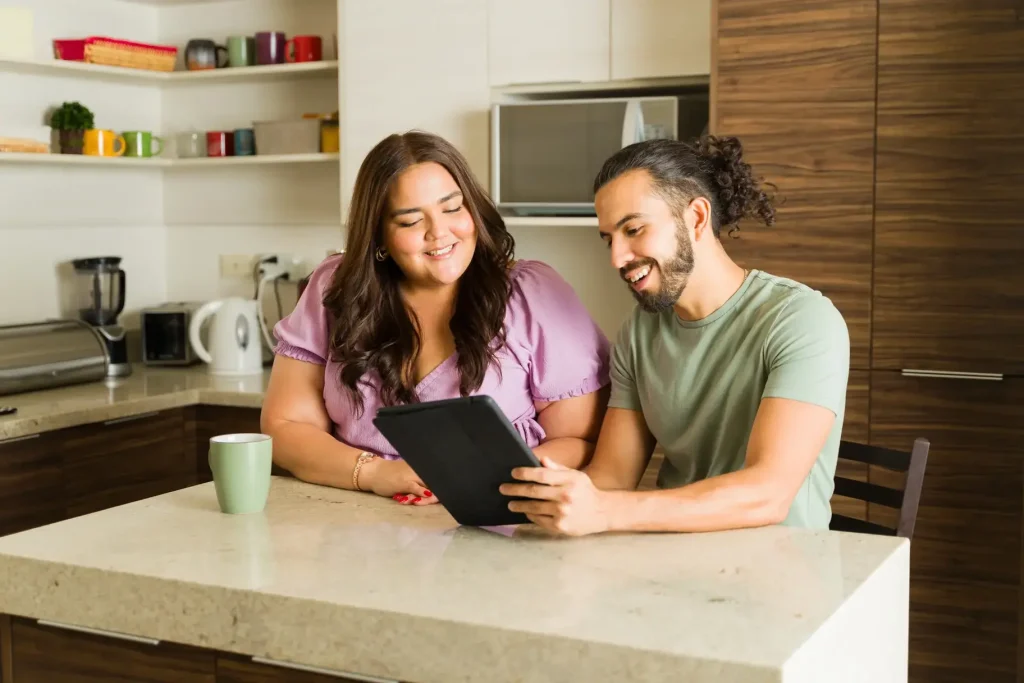 Man and woman in kitchen using tablet to refer someone to Bo Care